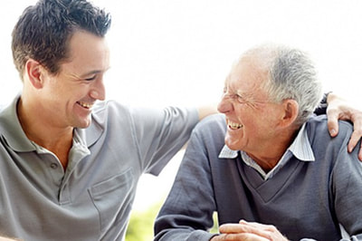 Adult son sitting with an older parent at home
